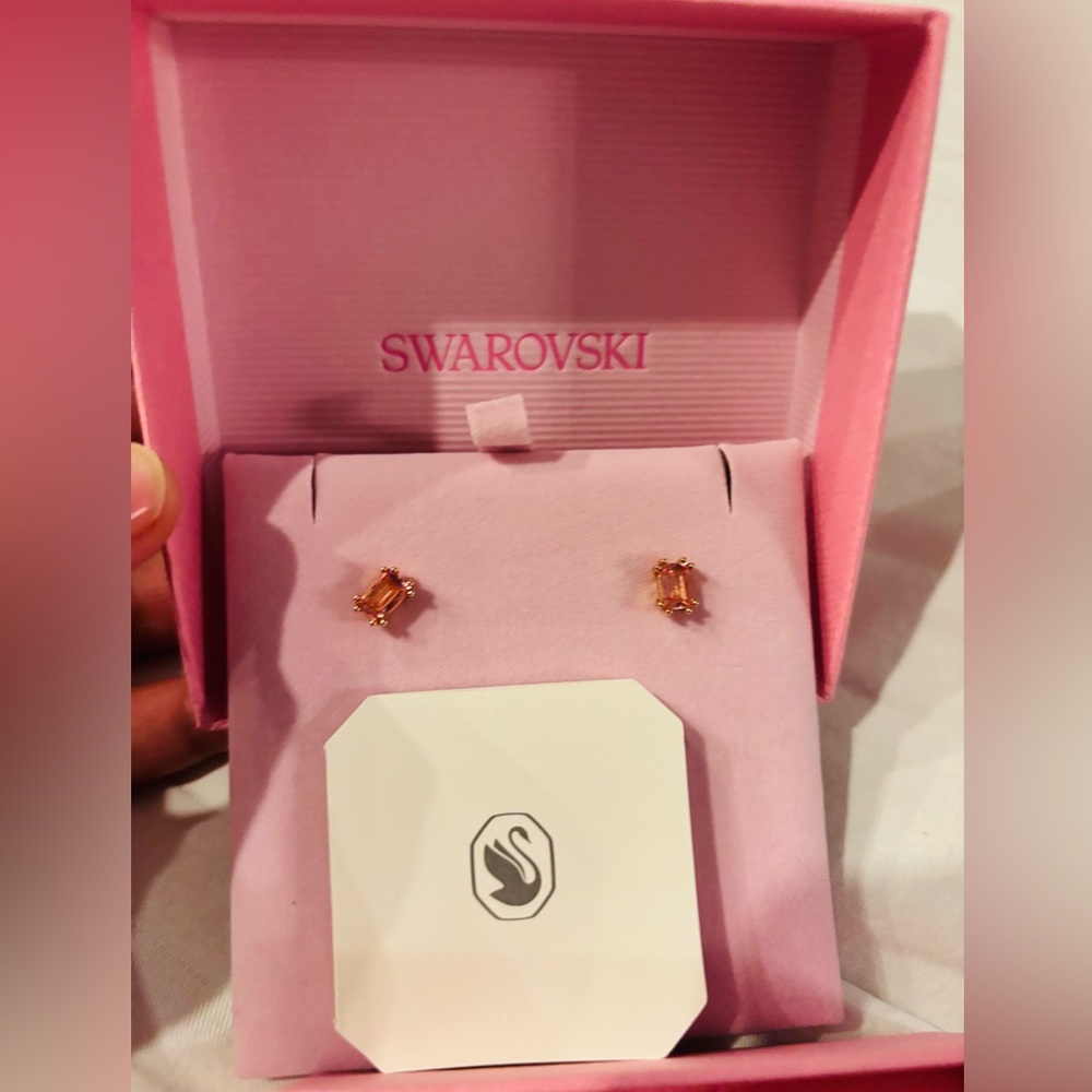 Swarovski crystal stud earrings with a pink cushion-cut stone and rose gold-tone